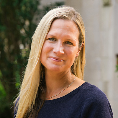 Woman with blonde hair wearing a navy blue shirt.