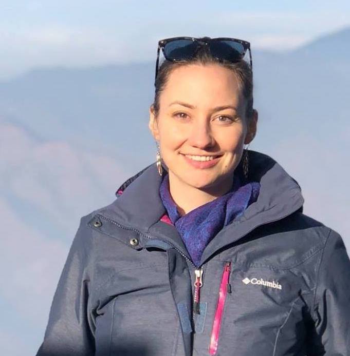 Woman wearing sunglasses and a navy blue jacket