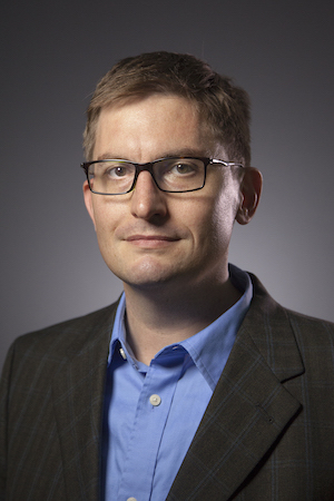 Portrait of someone in front of a gray background.