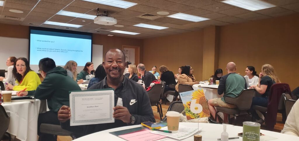 Jonathan Choti at a table with a certificate with his name on it