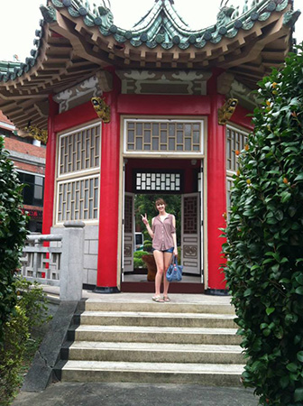 woman posing in front of asian architecture