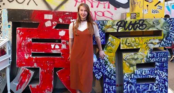 woman standing in front of brightly colored graffiti art