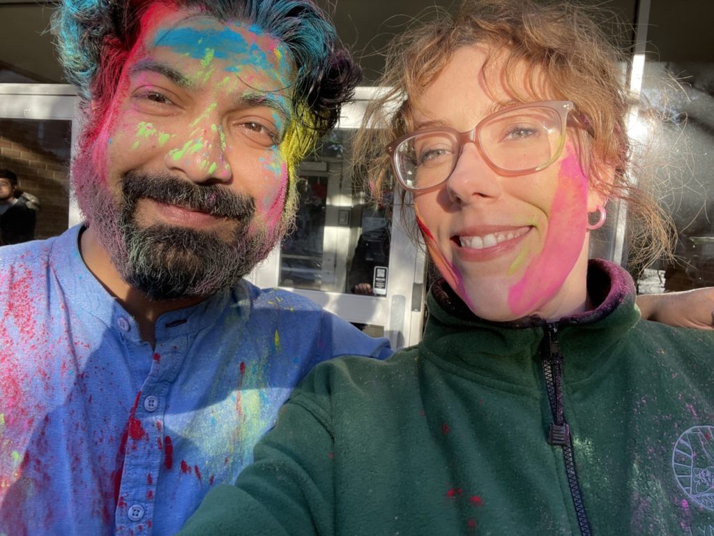 man on left and woman on right, both with colors on their faces and shirts