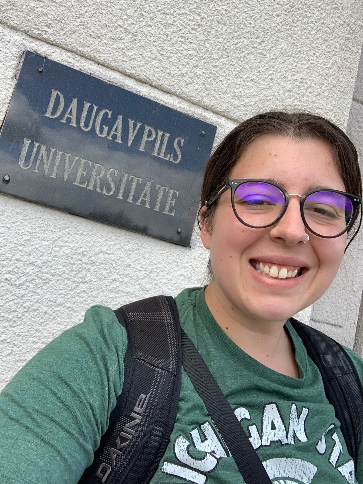 MSU student in front of a sign that says Daugavpils Universitate
