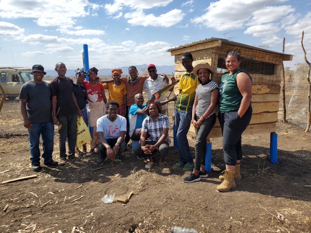 group participants in front of a chicken coop
