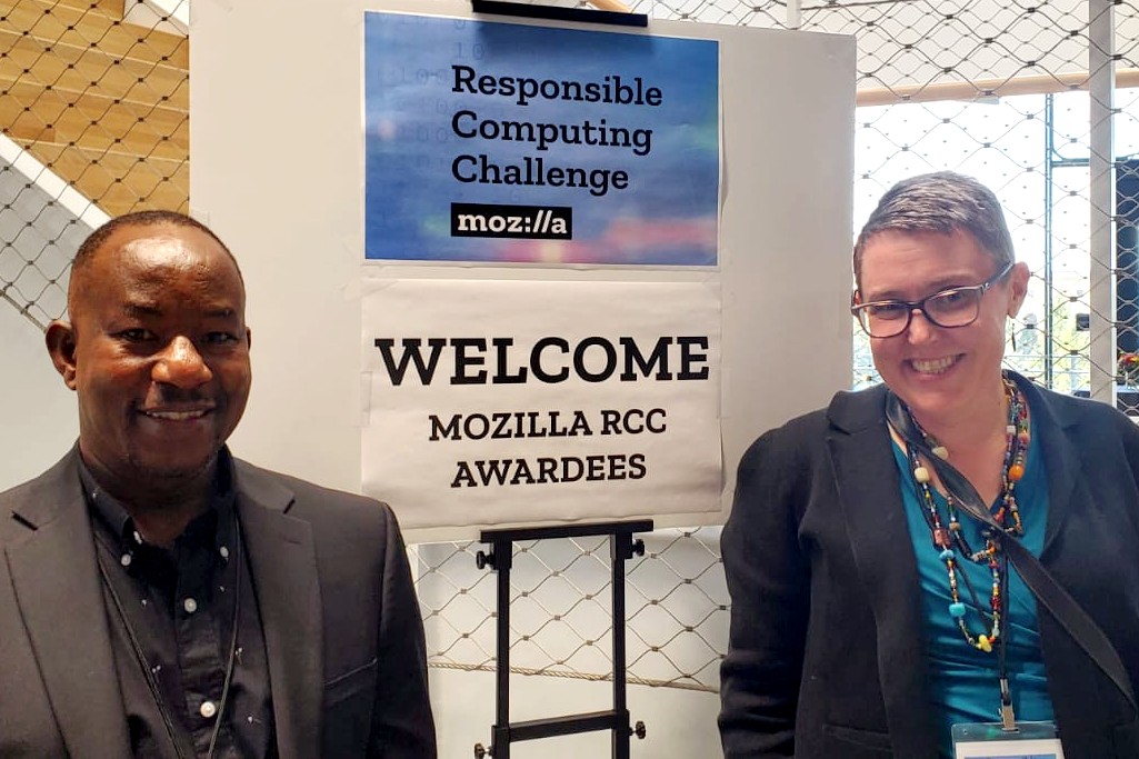 A man and woman standing next to a sign that says: "Responsible Computing Challenge: Welcome Mozilla RCC Awardees"