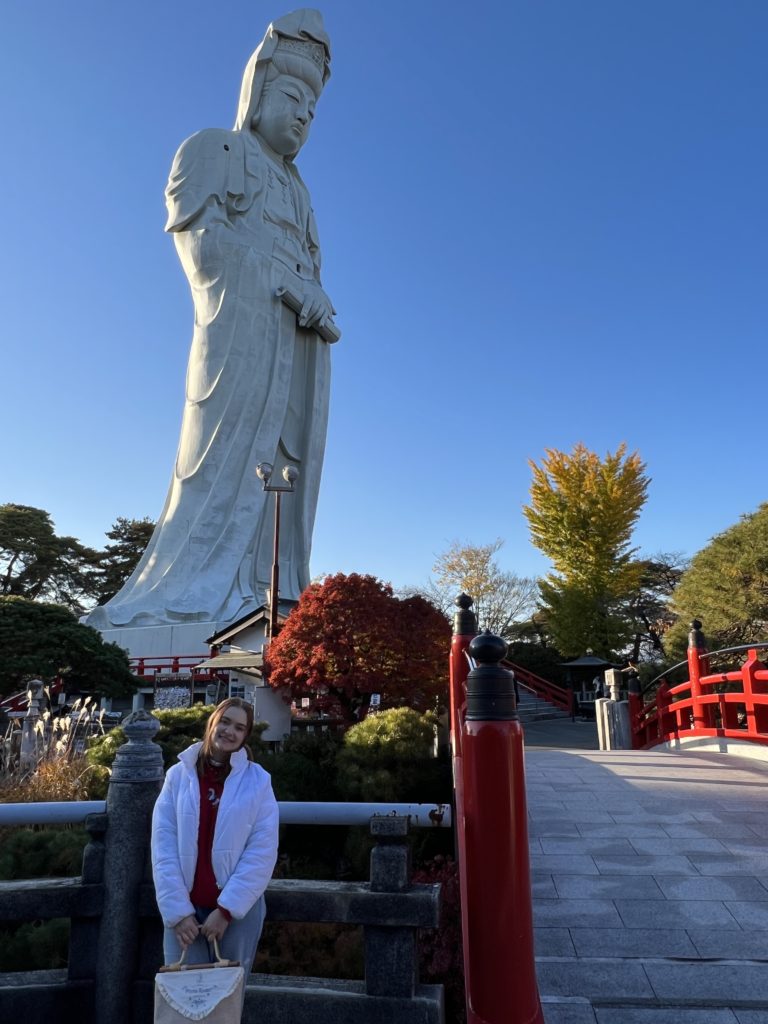 woman in front of Japanese statue